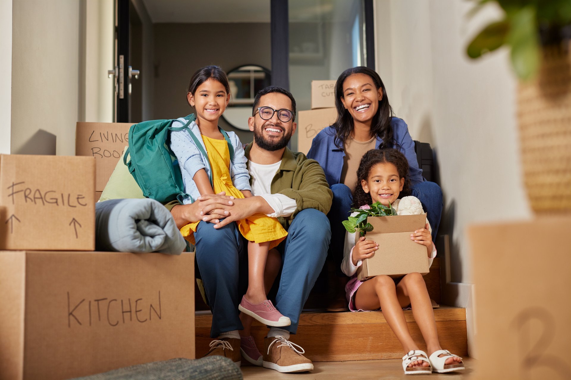 Happy family with cardboard boxes moving into new home