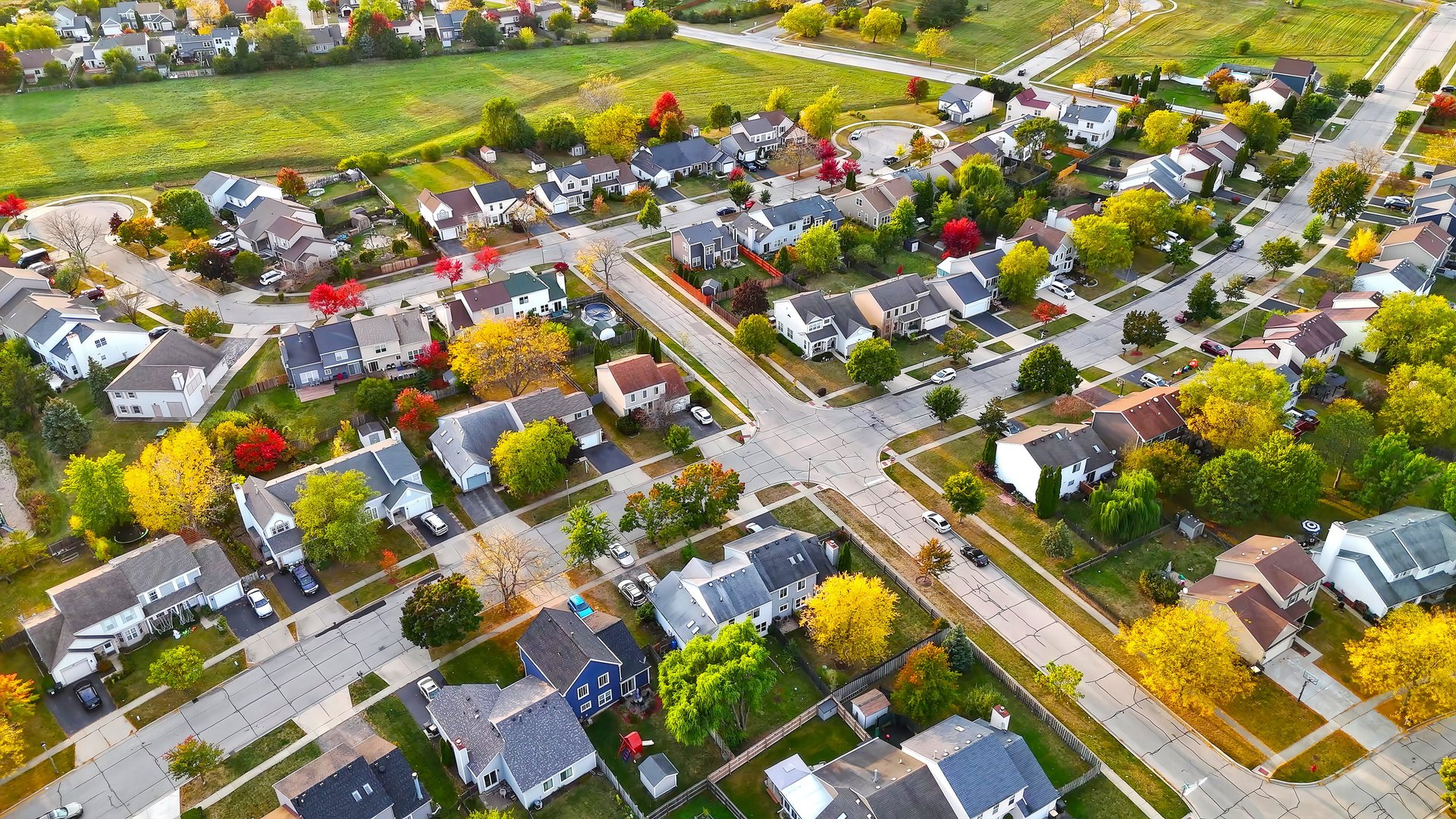 Aerial view of suburban neighborhood in autumn with colorful trees