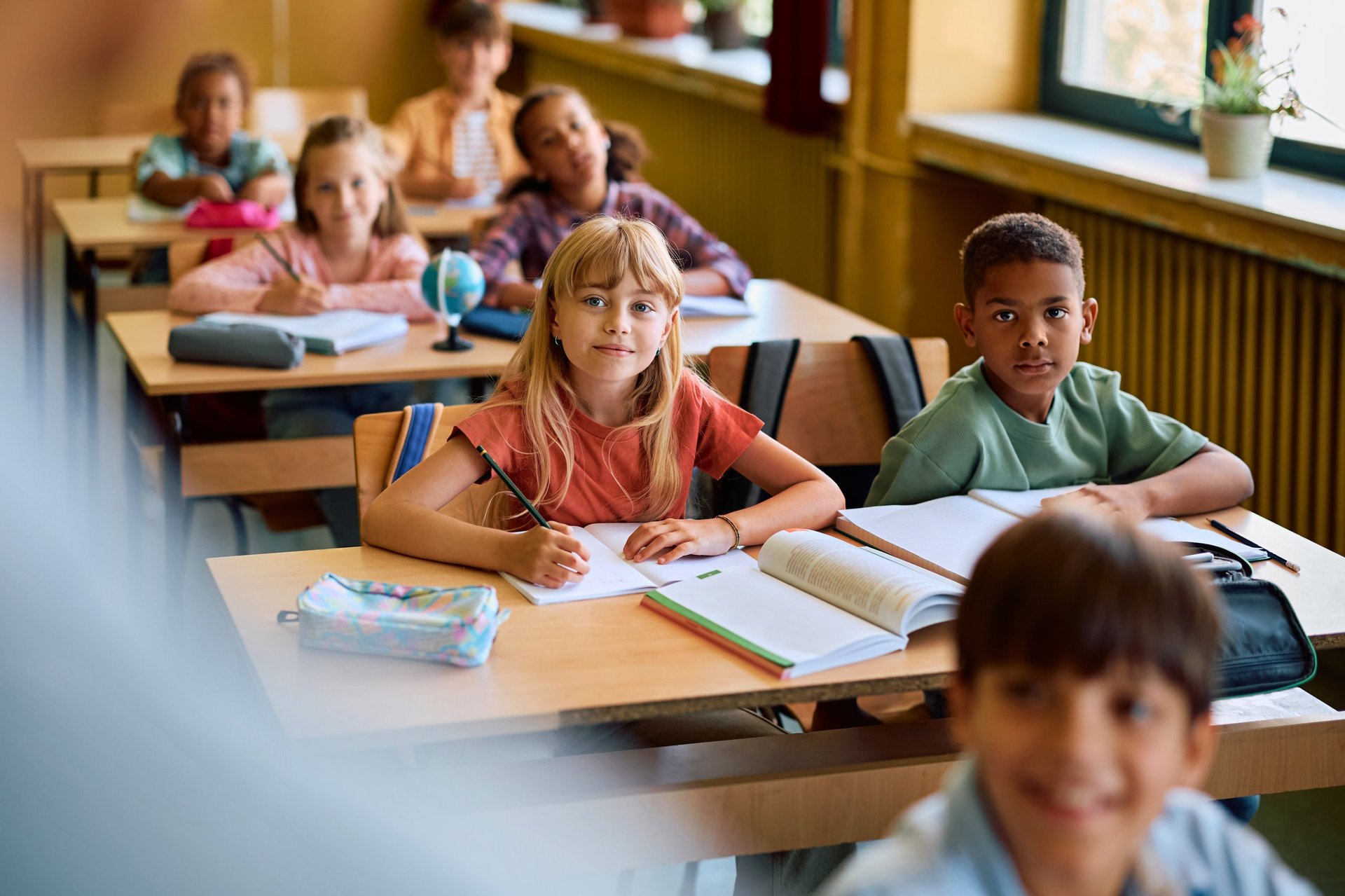 Diverse students listening to teacher in classroom