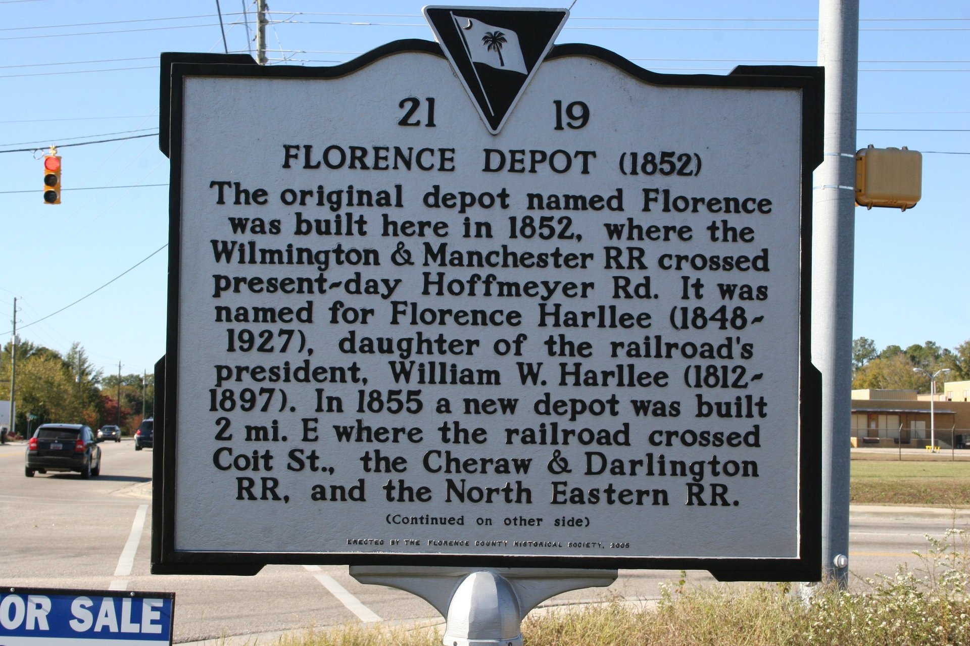 Historical marker sign 21-19 describing the Florence Depot built in 1852, located on a roadside with cars and trees visible