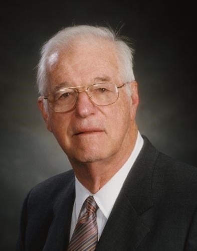 Professional headshot of Dr. Eddie Floyd, an older man with white hair and glasses wearing a dark blazer and striped tie